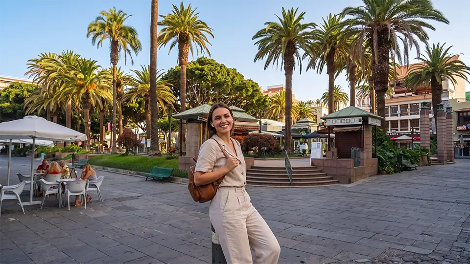 A woman listening to an audio guide in the Plaza del Charco in Puerto de la Cruz, Tenerife