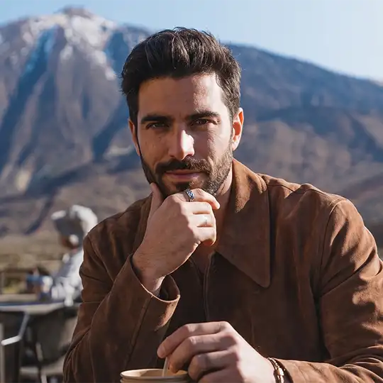 A visitor enjoying a hot chocolate in Teide National Park, with the snow-capped Teide in the background