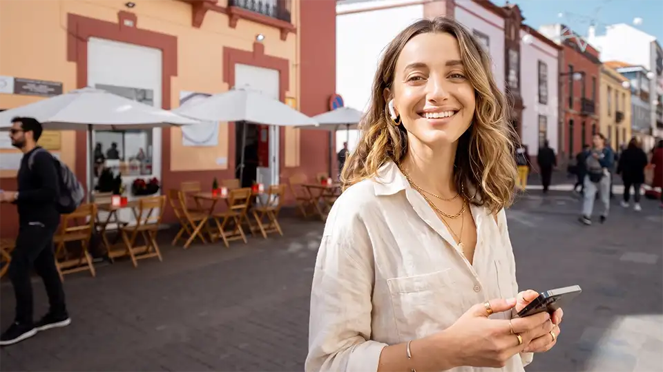 A traveller enjoying an immersive audio experience in the bustling streets of La Laguna, Tenerife