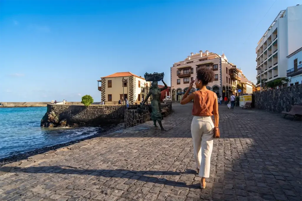 A traveller admiring the harbour and the sculpture honouring the fisherwomen-Puerto de la Cruz-Tenerife