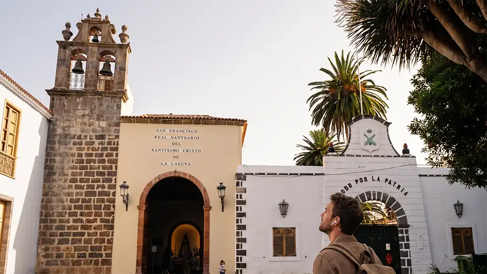 Ein junger Mann lauscht einem Audioguide und bewundert das Heiligtum Santísimo Cristo de La Laguna, Teneriffa