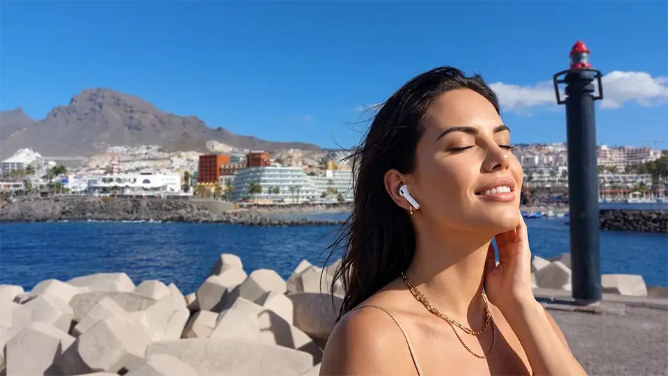 Une femme écoute un audioguide immersif à Puerto Colón – Costa Adeje – Ténérife