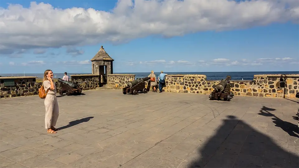 Une femme écoute un audioguide près des canons de la Plaza de Europa à Puerto de la Cruz, Ténérife