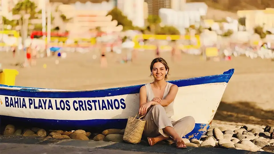 Ein Reisender genießt ein immersives Audioerlebnis am Strand von Los Cristianos